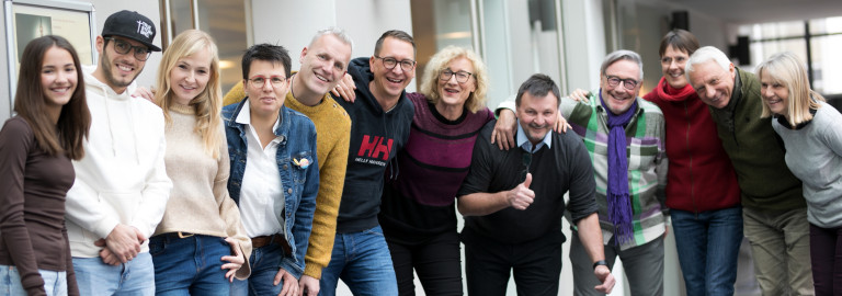 Eine Gruppe von lachenden Menschen aus unterschiedlichen Altersstufen