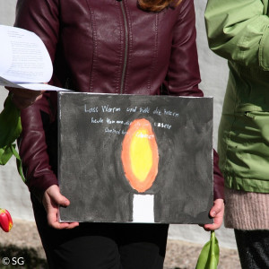 Jugendliche mit einem selbstgemalten Bild einer Kerze