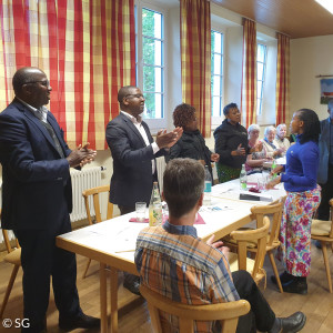 Gäste aus Mwika singen ein Lied bei einem Gemeindeabend in Neunkirchen